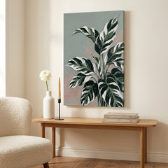 Obraz veľké listy tropickej rastliny s panašovaním zavesený v modernom štýlovom interiéri obývačky, nad drevenou konzolou s vázou a sviečkou.