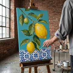 Umelkyňa v Papilora ateliéri stojí vedľa dreveného stojana s hotovým obrazom dva citróny na vetvičke, prirodzené denné svetlo z veľkého okna.