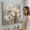 Kvetinový svet na plátne Potešenie pre vaše zmysly 100x100 cm. Moderná nástenná dekorácia, obraz na plátne do obývačky, žena obdivuje dielo v štýlovom svetlom interiéri. Papilora (XOBMDFL022E1).